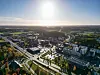 Ilmakuva Kaarinan keskustasta, teitä, taloja ja vihreitä alueita auringonpaisteessa.