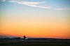 Auringonlasku ja lentokentän kiitotiet avoimen taivaan alla.