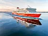 Punavalkoinen Viking Line -lautta kulkee tyynellä merellä auringonlaskun aikaan.