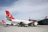 Flera Turkish Airlines-flygplan står parkerade på rampen vid en flygplats.