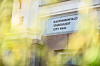 Kaupungintalon seinässä oleva kyltti, jossa lukee Kaupungintalo, Stadshuset ja City Hall, näkyy puiden lomasta.