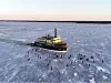 Jäänmurtaja kulkee jäätyneellä merialueella, ja sen ympärillä on useita ihmisiä jäällä.