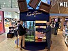 Kaksi miestä seisoo Karl Fazer -myymäläesittelyn edessä lentoaseman tax free -alueella.