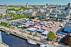 Ilmakuva torista, pysäköidyistä autoista, markkinakojuista ja satama-altaasta Oulussa.