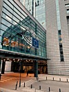 Lasinen toimistorakennus, jossa on Euroopan unionin tähtiä kuvaava tunnus ja sisäänkäynti kadun tasossa.