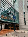 Lasinen toimistorakennus, jossa on Euroopan unionin tähtiä kuvaava tunnus ja sisäänkäynti kadun tasossa.