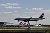 Matkustajakone lentää matalalla kiitotien yläpuolella Heathrow’n lentoasemalla.
