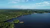 Ilmakuva suuresta järvestä, metsäisistä rannoista ja pienistä saarista.