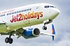 Lentokone, jossa lukee Jet2holidays, lentää laskutelineet alhaalla pilvisellä taivaalla.