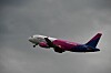 Wizz Airin matkustajakone lentää harmaata taivasta vasten.