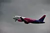 Wizz Airin matkustajakone lentää harmaata taivasta vasten.