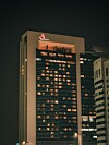 Yökuva korkeasta Marriott-hotellista, jonka ikkunoissa palaa valoja kaupungin horisontissa.