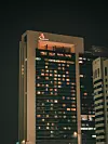 Yökuva korkeasta Marriott-hotellista, jonka ikkunoissa palaa valoja kaupungin horisontissa.