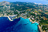 Flygfoto över en kustort med stränder, bostäder, grönområden och turkost vatten. Mallorca, Spanien.