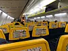 Tom kabin i ett Ryanair-flygplan med gula säten och reklam på stolsryggarna.