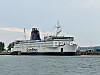 Scandlines-färjan M/F Kronprins Frederik vid kaj i en lugn hamn med grå himmel.