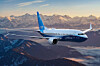 Ett Boeing 737 Max 7-flygplan flyger över berg i kvällsljus.
