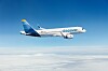 Discover Airlinesin matkustajakone lentää sinisellä taivaalla pilvien yllä.