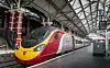 Rött och gult höghastighetståg från Virgin står vid en täckt järnvägsplattform.