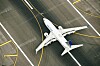 Ett vitt United Airlines-passagerarflygplan taxar på en flygplats, sett ovanifrån.
