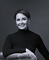 S-ryhmän uusi matkailu- ja ravitsemiskaupan ketjujohtaja Laura Tarkka mustassa poolokauluspaidassa tummalla taustalla.