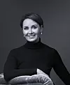 S-ryhmän uusi matkailu- ja ravitsemiskaupan ketjujohtaja Laura Tarkka mustassa poolokauluspaidassa tummalla taustalla.