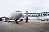 Ett passagerarflygplan står vid en flygplatsterminal med en passagerarbrygga ansluten.